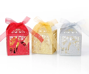 Laser-cut wedding candy boxes with glitter finish and elegant bride and groom silhouettes
