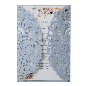 Macro view of laser-cut rose hollow invitation with pearlescent light blue cover