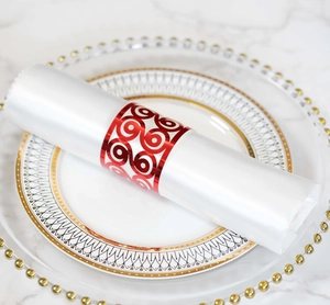 Close-up of red laser-cut scroll pattern napkin ring on elegant black and gold china plate
