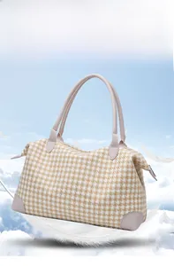 Détail du sac de voyage pied-de-poule avec bordure en cuir rose et doubles poignées de yoga