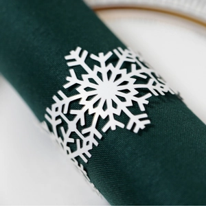 Rond de serviette flocon de neige blanc sur serviette verte pour table de Noël