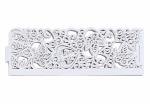 Close-up of laser-cut hollow pattern with hearts and leaves on a white decorative frame