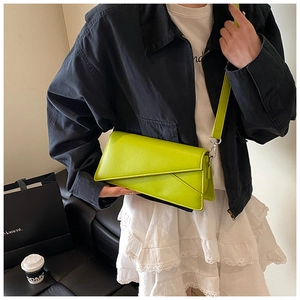 Detail of trendy neon green crossbody bag with geometric flap and silver hardware