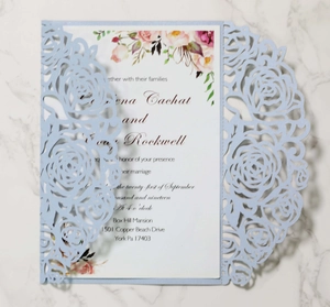 Macro detail of laser-cut rose hollow invitation with elegant floral inner wedding card