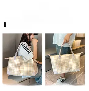 Détails du grand sac de voyage avec motif pied-de-poule et poignées en cuir rose