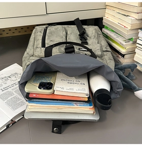 Detailed internal view of large capacity grey marble backpack showing laptop and books storage
