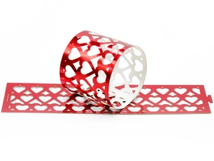 Close-up of red metallic heart-shaped cutout napkin rings for wedding decor