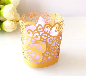 Macro detail of gold laser-cut paper lampshade with heart and leaf patterns for LED candles