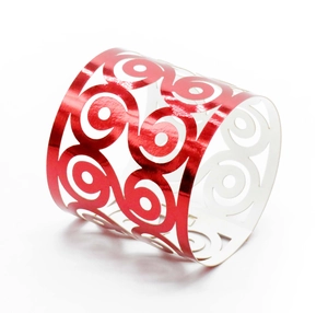 Detail of red laser-cut napkin ring with intricate scroll patterns for wedding decor
