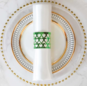 Detail of green laser-cut heart pattern paper napkin ring on a white satin napkin