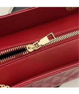 Close-up of golden zipper hardware on a red bridal tote bag with smooth texture