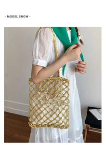 Model shot of a hollow knit tote bag in gold with a white drawstring inner pouch