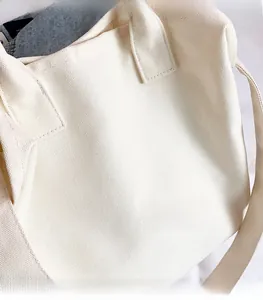 Close-up of the thick off-white canvas texture and wide strap of the minimalist tote bag