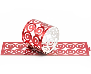 Detailed laser-cut red metallic napkin ring with ornate scroll patterns for festive parties