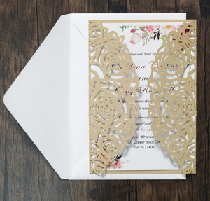 Detail of laser-cut gold floral wedding invitation set with inner card and envelope