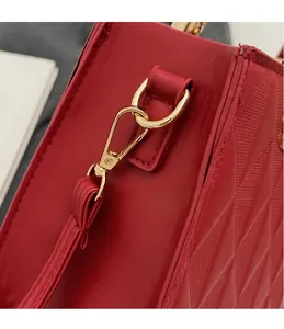Detail of high-quality golden metal hook and quilted red leather on large tote bag