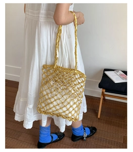 Detail of gold hollow mesh tote bag with white drawstring lining for beach and vacation
