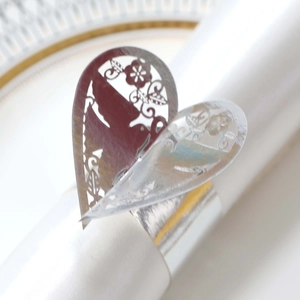 Détail macro du rond de serviette cœur découpé au laser avec oiseaux et fleurs