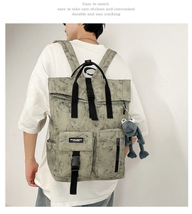 Detail of marble pattern backpack with multi-pocket design and plush frog keychain charm