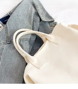 Close-up of off-white canvas tote bag with thick handles and textured fabric details