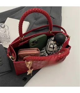 Macro view of red tote bag featuring quilted texture, woven handles and large storage space