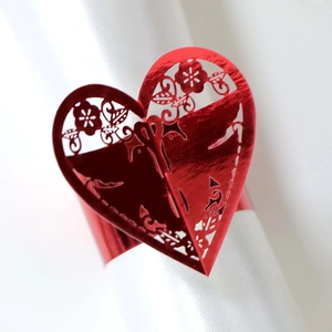Vue détaillée du rond de serviette cœur rouge découpé au laser avec motifs floraux fins