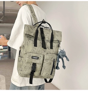 Detail of grey marble pattern backpack with buckles and blue frog plush charm