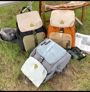 Outdoor leisure backpacks in mixed colors with buckle closures on a grass field