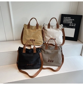 Detailed group view of colorful canvas tote bags with XOG embroidery on marble steps