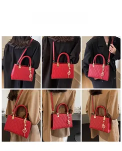 Detail view of red quilted tote bag with round handles and heart pearl charm on a model