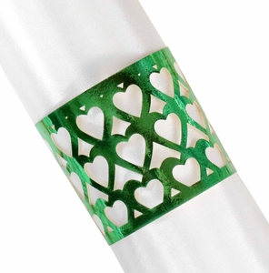 Close-up of green heart-shaped cutout napkin ring on a white satin cloth
