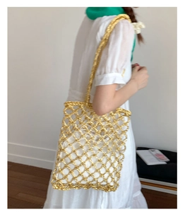 Detail of gold metallic woven tote bag featuring a hollow grid and white inner pouch