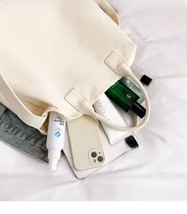Macro shot of cream white canvas tote bag showing spacious interior with daily essentials