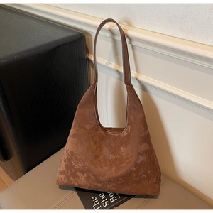Detailed close-up of brown suede hobo tote bag featuring vintage textured leather material