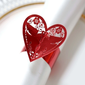Détail du rond de serviette en cœur rouge avec motifs floraux découpés au laser