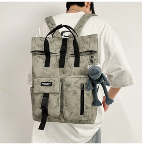 Detail of marble pattern backpack with dual front pockets and a blue plush mascot