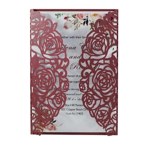 Macro view of laser-cut burgundy rose wedding invitation with a floral insert card