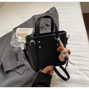Black litchi grain bucket bag with a cute plush dog pendant and detachable strap