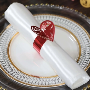 Gros plan d'un rond de serviette coeur rouge ajouré pour décoration de mariage