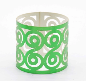 Detail of green spiral pattern cutout napkin ring with modern metallic texture finish