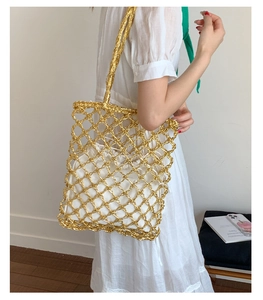 Detailed shot of golden woven mesh bag with creamy white drawstring inner pouch