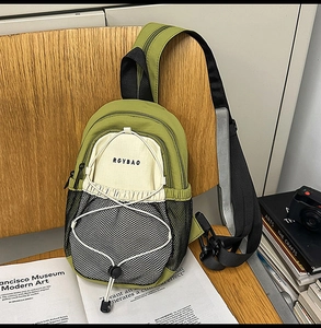 Détail du sac bandoulière en nylon vert avec poche filet et cordon de serrage élastique