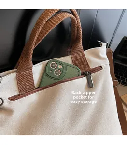 Detail view of the back zipper pocket on a beige canvas tote bag for secure storage