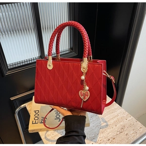 Red quilted tote bag with woven handles and golden Double Happiness heart charm detail