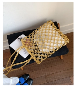 Detailed view of gold woven tote bag featuring mesh structure and white linen drawstring liner