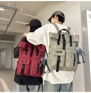Macro view of burgundy and sage green canvas backpacks with multiple functional pockets