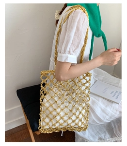 Detail of gold woven tote bag featuring white drawstring liner and large hollow mesh pattern