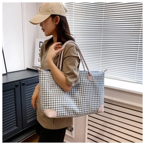 Détail du grand sac de voyage à motif pied-de-poule bleu avec poignées en cuir chic