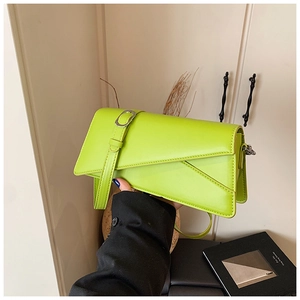 Detail of neon green leather crossbody bag with asymmetric flap and silver metal buckle