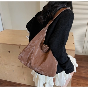 Close-up of a vintage brown hobo bag with marble texture showing suede leather texture